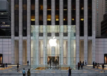 Symbolic image for Apple government affairs: the glass entrance cube of the Apple Store on Fifth Avenue in New York at dusk