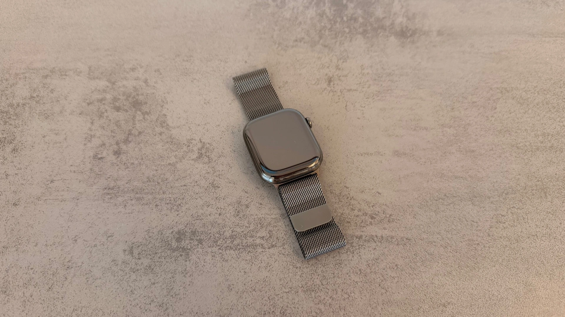 Apple Watch Series 11 in slate titanium with a Milanese loop, whose rectangular display Apple could replace with new shapes according to the report