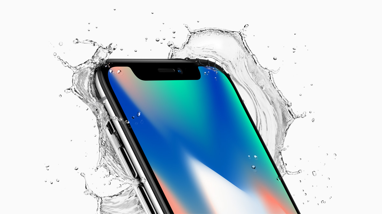 The iPhone X surrounded by splashing water on a light background, now classified as obsolete by Apple