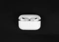 AirPods Pro with wireless charging case against a black background