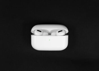 AirPods Pro with wireless charging case against a black background