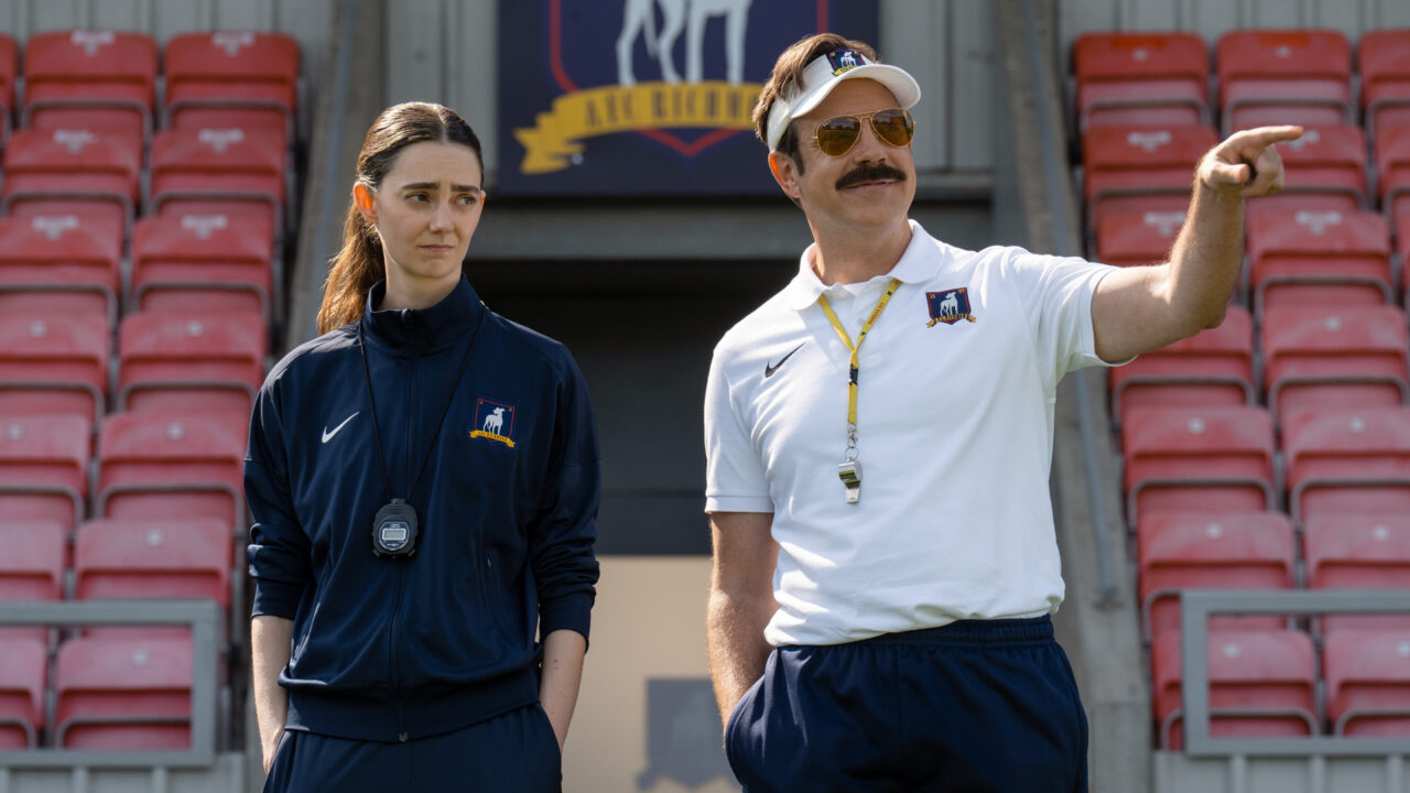 Ted Lasso standing beside a coach in the empty AFC Richmond stadium while Apple has yet to decide on Ted Lasso season 5