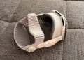 Apple Vision Pro with light Dual Knit Band resting on its side on a grey woven sofa surface