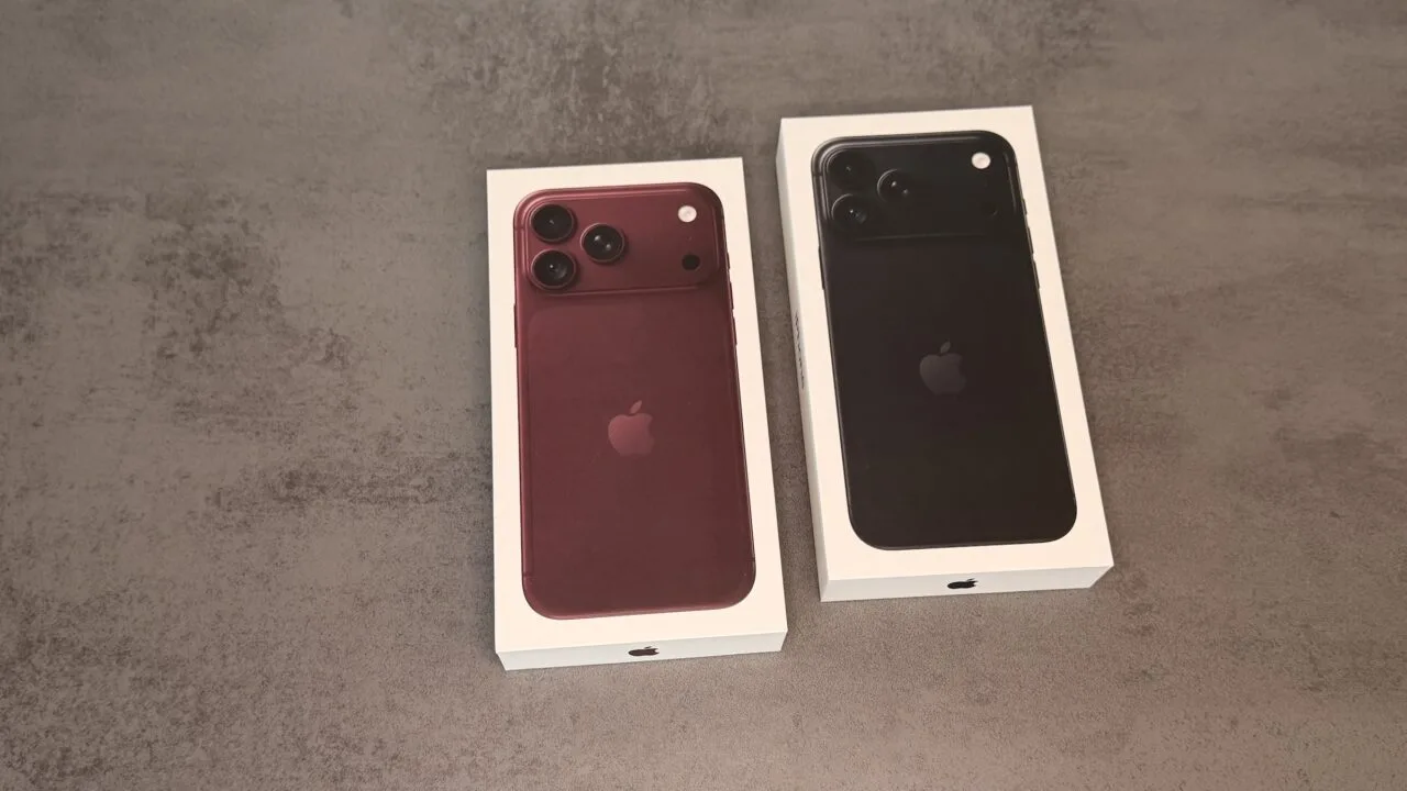Two boxed iPhone 18 Pro Max units in burgundy and black side by side on a grey stone surface – representing the demand behind the new Apple stock price target
