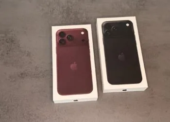 Two boxed iPhone 18 Pro Max units in burgundy and black side by side on a grey stone surface – representing the demand behind the new Apple stock price target