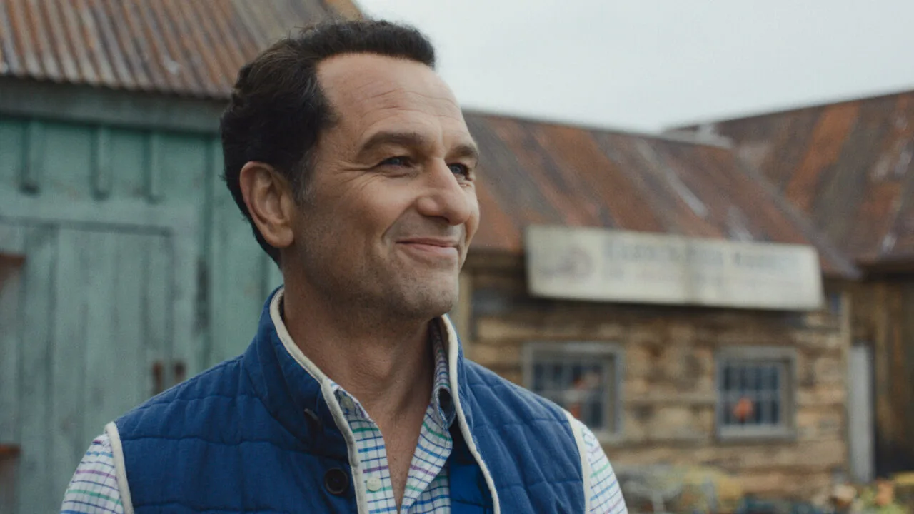 Apple TV Emmys: Matthew Rhys as the mayor in the series Widow's Bay in front of the island town's wooden houses