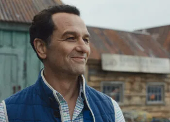 Apple TV Emmys: Matthew Rhys as the mayor in the series Widow's Bay in front of the island town's wooden houses