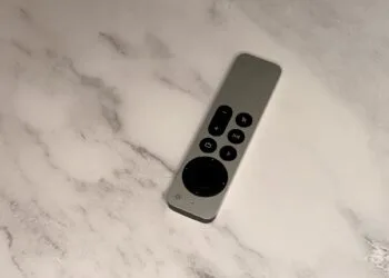 Apple TV 4K Siri Remote lying diagonally on a light marble surface