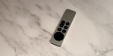 Apple TV 4K Siri Remote lying diagonally on a light marble surface