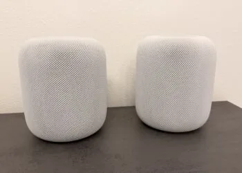 HomePod surround: two white HomePod speakers side by side on a dark countertop
