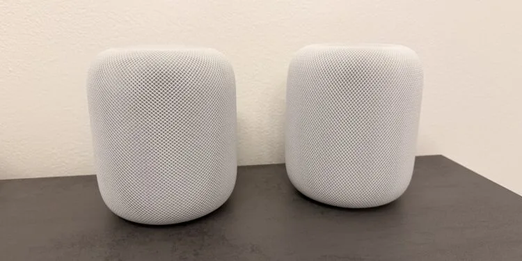 HomePod surround: two white HomePod speakers side by side on a dark countertop