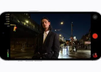 Final Cut Camera on an iPhone 18 Pro in landscape showing an f/1.48 aperture while filming a man at night on a city street