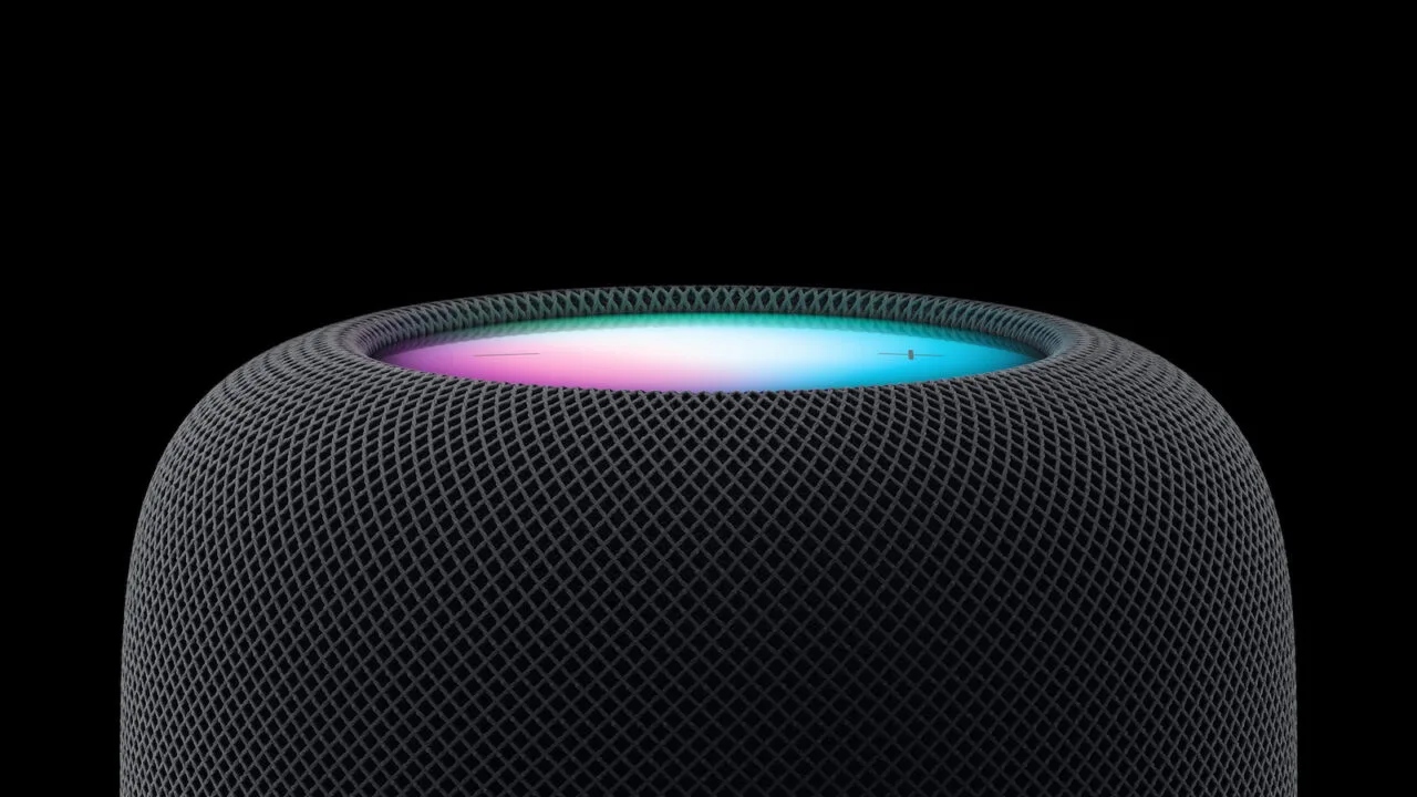 HomePod Siri AI: top of a midnight HomePod with a glowing Siri light in pink and turquoise against a black background