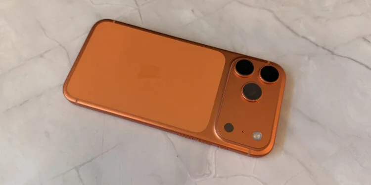 Camera module of an orange iPhone, related to the iOS 27 camera features found in code