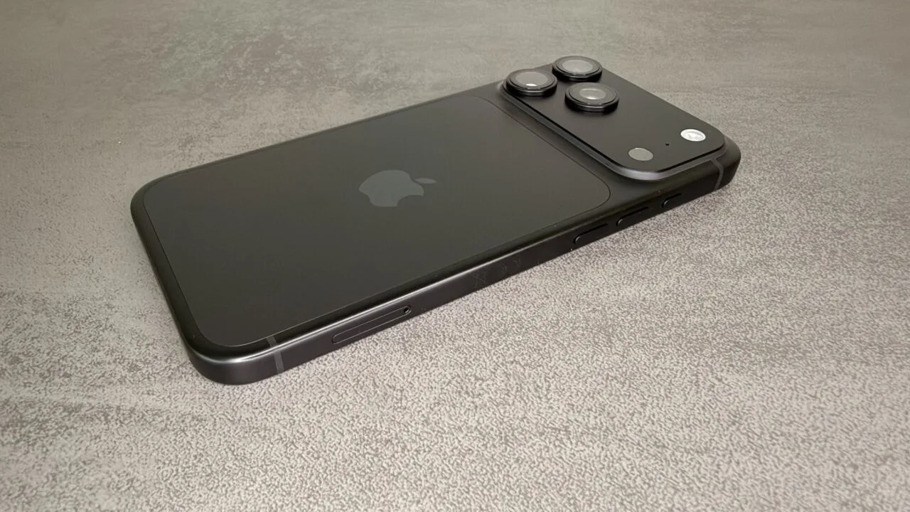 Black iPhone 18 Pro from the back with camera plateau on a grey stone surface – one of the devices for which users report iPhone 18 Pro reboots