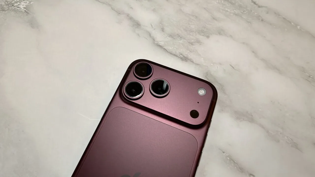 Close-up of the camera system of a burgundy iPhone 18 Pro Max on light marble – the main camera the iPhone 18 Pro uses for Cinematic mode effects and 4K time-lapse