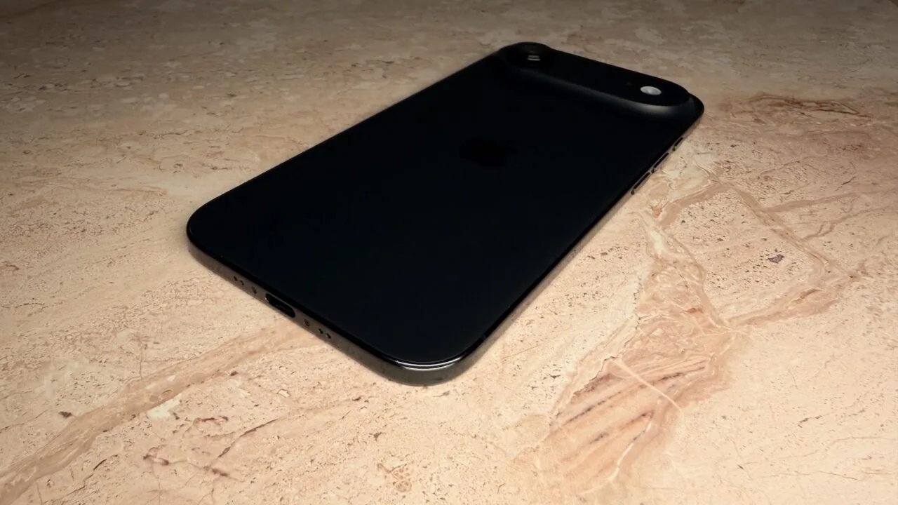 iPhone roadmap: a black iPhone lying face down on a light stone surface