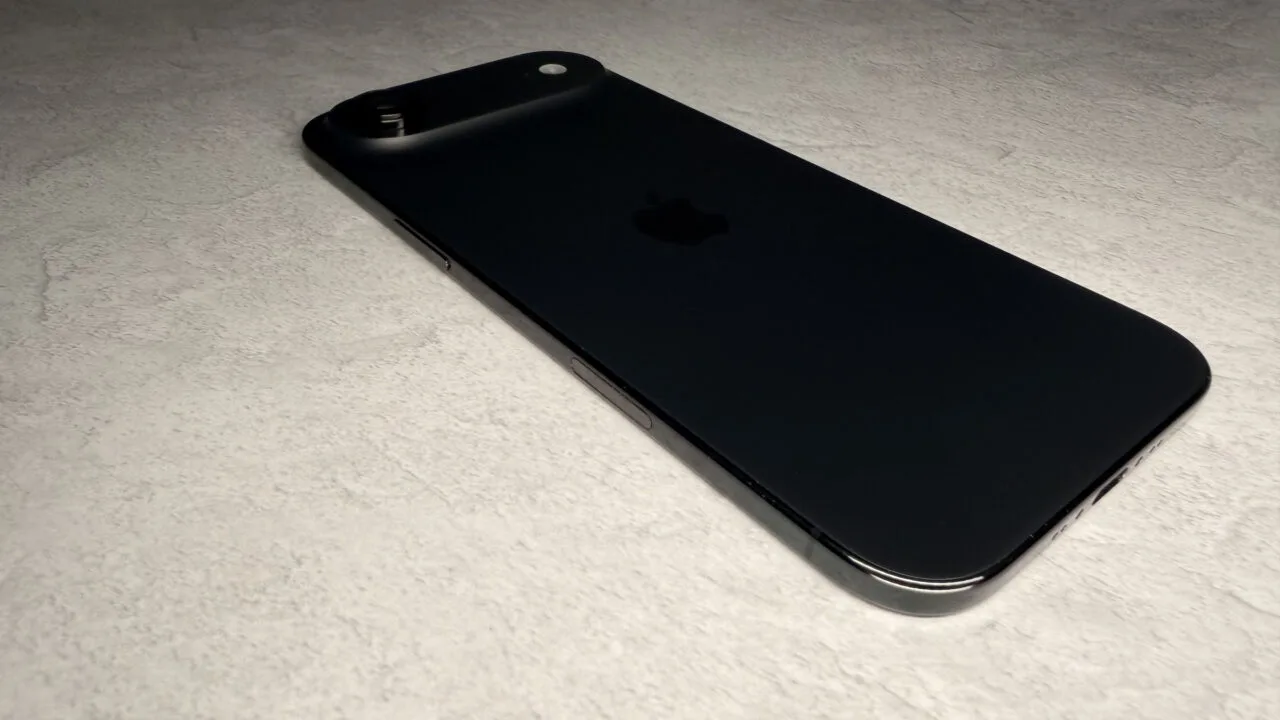 iPhone Ultra market share: black iPhone Air lying flat, viewed from the side on light stone