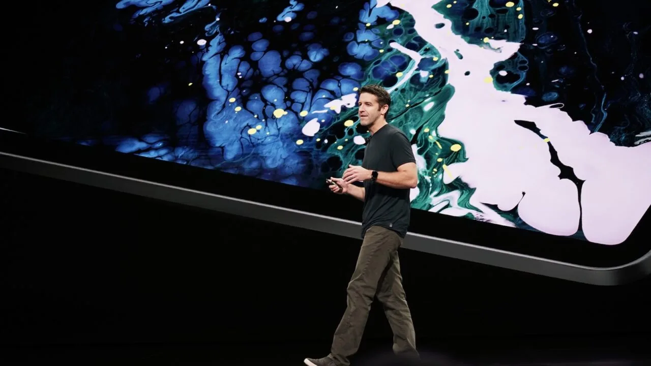 New Apple CEO John Ternus speaking on a keynote stage in front of a large projection