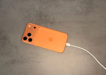 iPhone in an orange case connected to a USB-C cable, the starting point for juice jacking at unknown ports