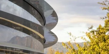Glass facade of Apple Park with curved canopies in the evening sun – Apple secures the team and patents of Ascend.io