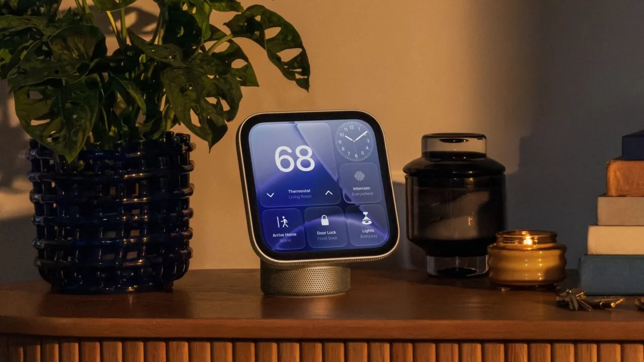 Apple HomeView repair: HomeView on a wooden sideboard showing thermostat, clock, intercom and controls for the door lock and lights, next to a plant and a candle