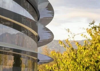 Apple earnings: glass facade of the Apple Park ring with curved canopies, trees and hills on the right