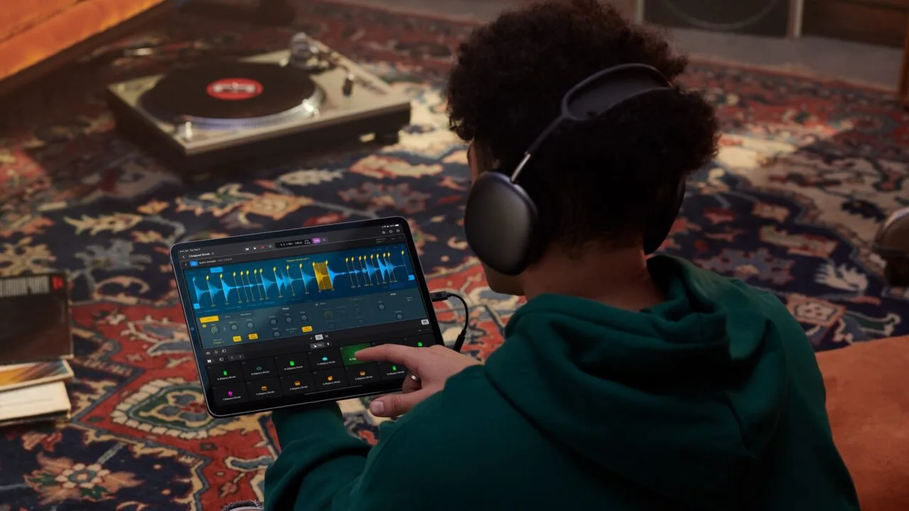 Apple Samplab: person wearing headphones editing an audio track split into slices in Logic Pro on iPad, with a turntable in the background