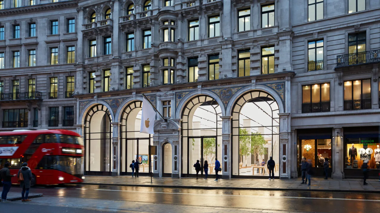 Apple Store Regent Street in London at dusk with four glass arches, a white Apple flag and a red double-decker bus, representing the Apple Stores that received boxes with an embargo date