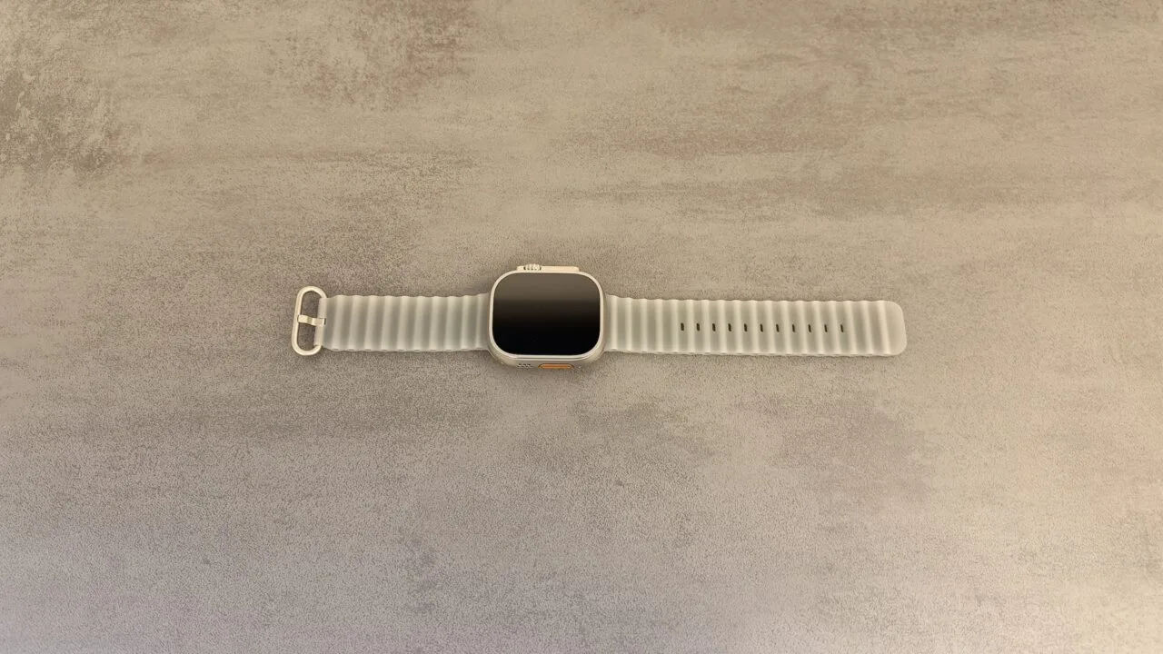 Apple Watch Ultra 4 with a grey Ocean Band on a grey stone surface, whose sensor technology is at the centre of the legal dispute between Apple and Oppo