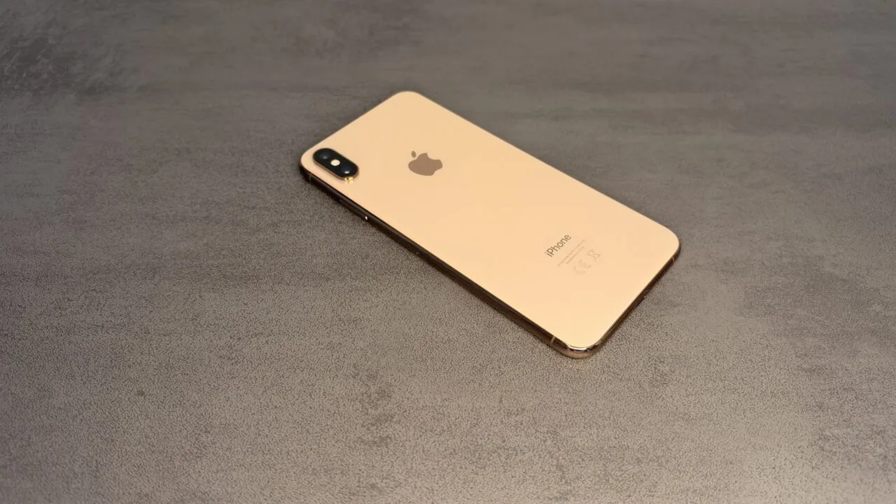 Gold iPhone with dual camera on a grey surface – iPhones without current updates are the target of DarkSword