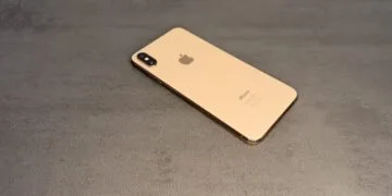 Gold iPhone with dual camera on a grey surface – iPhones without current updates are the target of DarkSword