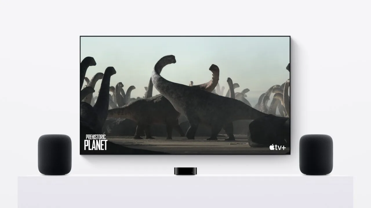 HomePod stereo pair: two HomePods on either side of a TV, with an Apple TV in the middle on a white sideboard