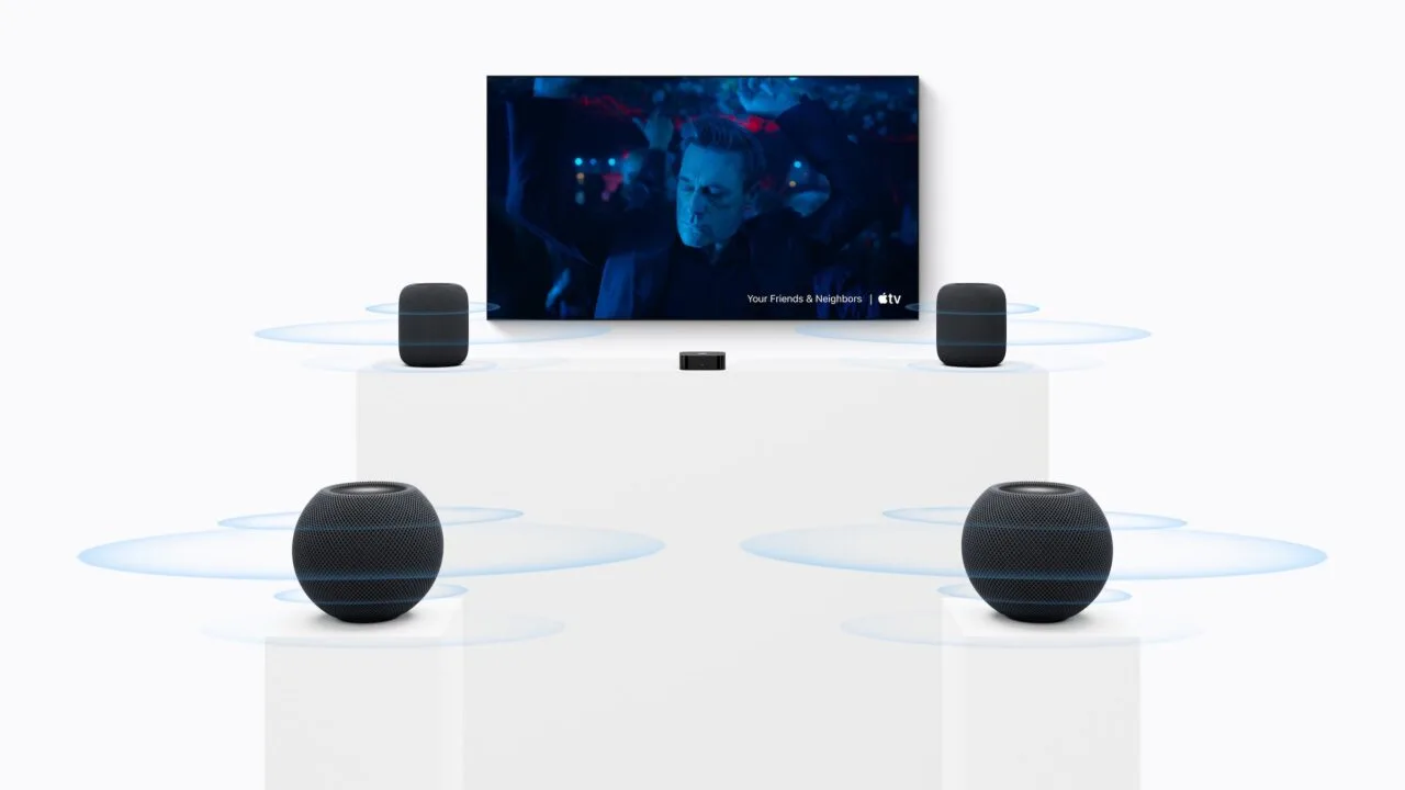 HomePod surround settings: two large HomePods beside a TV, two HomePod mini speakers on pedestals in front and an Apple TV in the middle