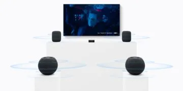 HomePod surround settings: two large HomePods beside a TV, two HomePod mini speakers on pedestals in front and an Apple TV in the middle