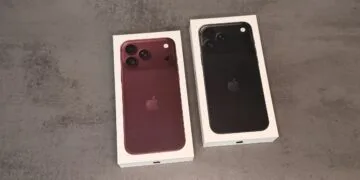 Two iPhone 18 Pro boxes in burgundy and black on a grey surface