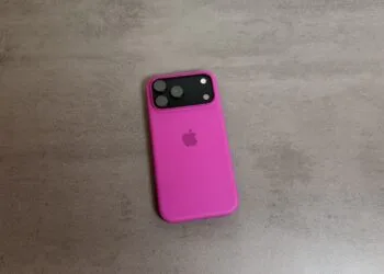 An iPhone 18 Pro series model in a pink silicone case on a grey stone surface; the series put Apple first in China