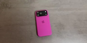An iPhone 18 Pro series model in a pink silicone case on a grey stone surface; the series put Apple first in China