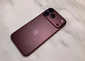 iPhone China market share: a dark red iPhone from the Pro lineup seen from the back on a light marble surface, with camera plateau and three lenses
