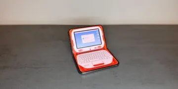 One of the adapted iPhone Duo apps turns the half-folded iPhone Duo on a table into an orange retro laptop with the screen on top and the keyboard below.