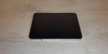 iPhone Duo inner display: the unfolded iPhone Duo lies flat on a grey table with its display switched off