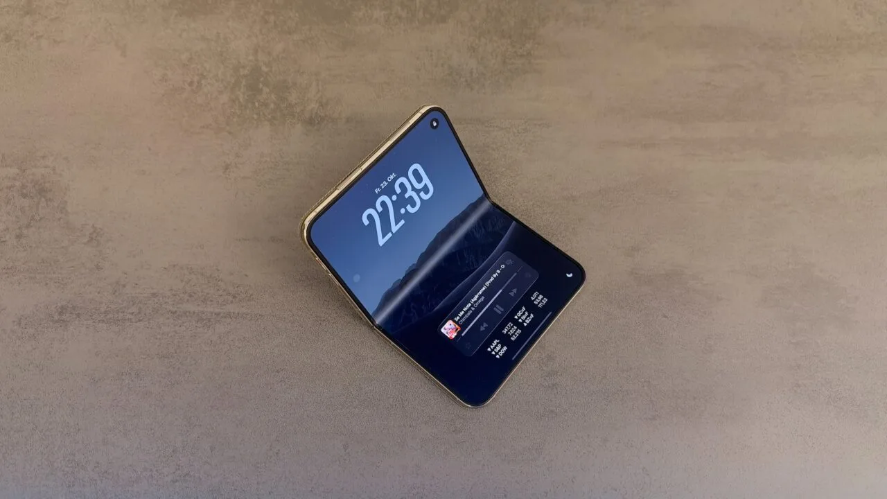 iPhone Duo display crack: an intact, half-unfolded iPhone Duo on a stone surface, the crease of the inner display showing as a light stripe in the light