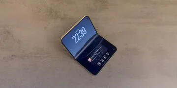 iPhone Duo display crack: an intact, half-unfolded iPhone Duo on a stone surface, the crease of the inner display showing as a light stripe in the light