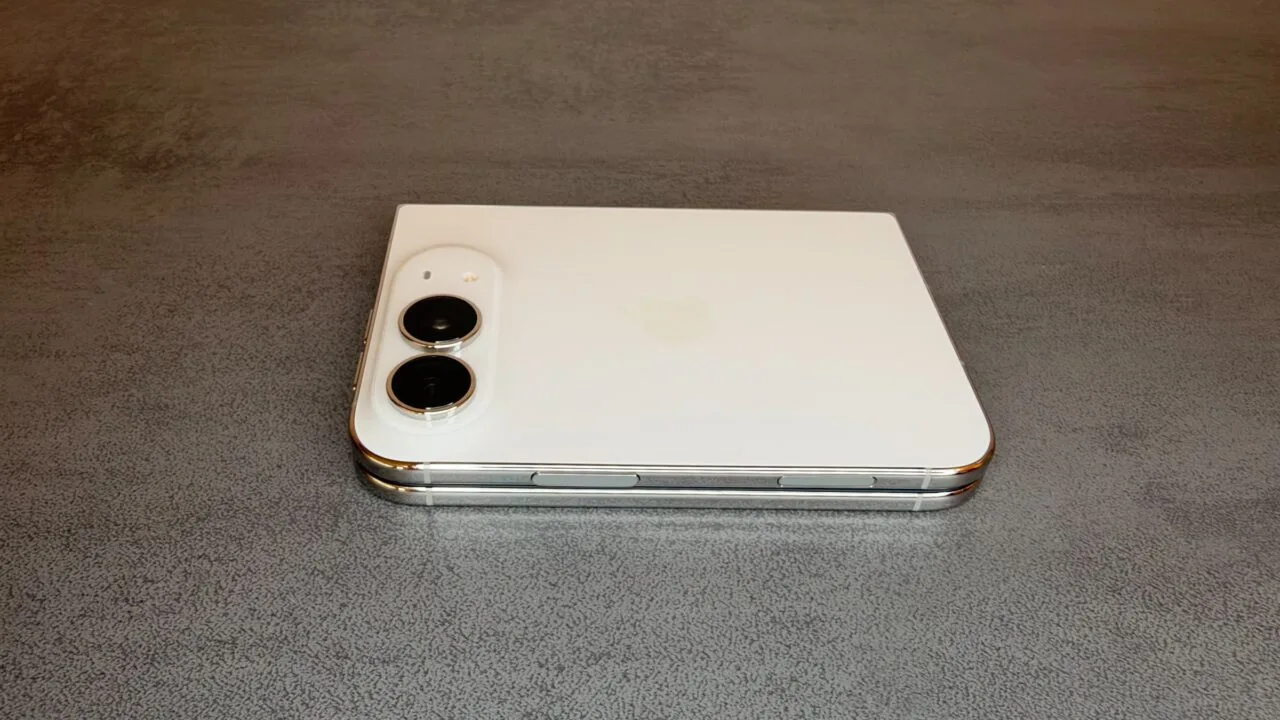 iPhone Duo camera preview: the folded white iPhone Duo lies on a grey table with its two rear cameras in the top left
