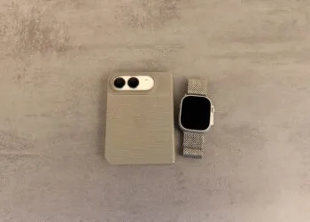 Unlocking iPhone Duo with Apple Watch: folded iPhone Duo in a case, camera side up, next to an Apple Watch Ultra with a mesh band on a grey stone surface