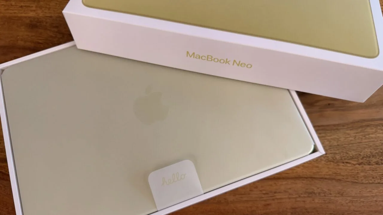 Freshly unboxed yellow MacBook Neo with hello tab in its box on a wooden table – illustrating Mac shipments in the third quarter