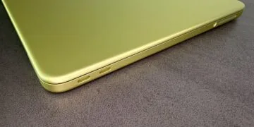 Closed MacBook Neo in Citrus with two USB-C ports on a dark tabletop, on the rising Mac market share in a shrinking PC market