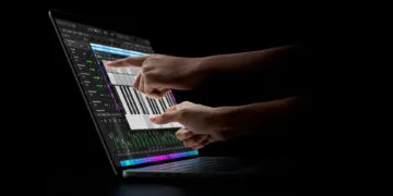 MacBook Pro touch: two hands playing an on-screen keyboard in Logic Pro on the display of a MacBook Pro with PROLED XDR Display