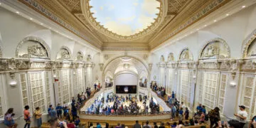 New Macs and iPad mini expected to be shown in Los Angeles: the Apple Tower Theatre store with its ornate dome, gallery and many visitors in front of the stage with the Apple logo