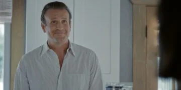 Ahead of Shrinking season 4: Jason Segel as Jimmy in an earlier episode, smiling in a kitchen, a blurred person in the foreground on the right